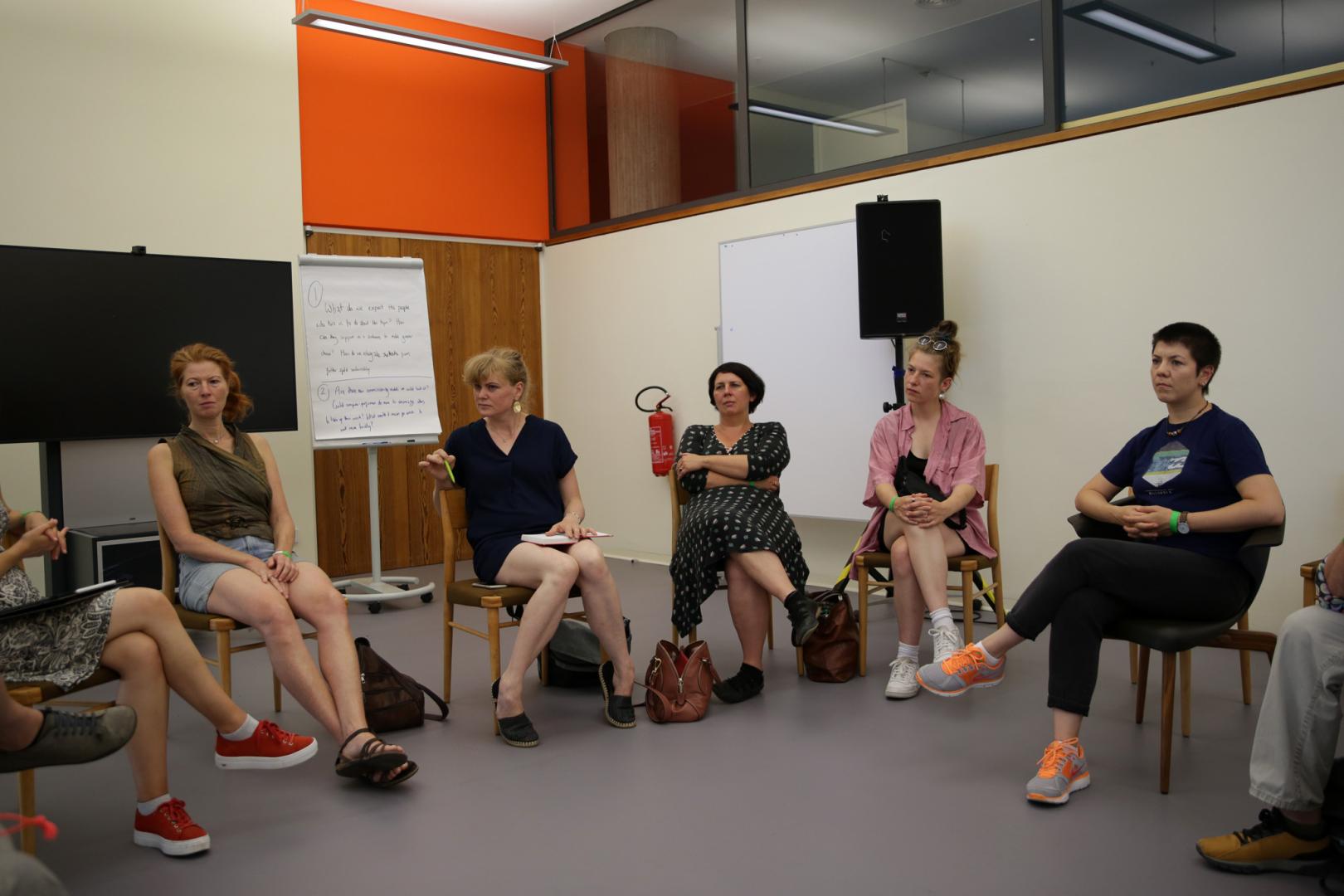 Workshop von Mimi Doulton, mehrere Personen sitzen auf Stühlen im Kreis